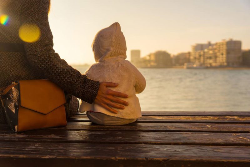 joven madre con bebe viendo atardecer playa Torrevieja